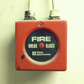 Red retro style fire alarm on the wall