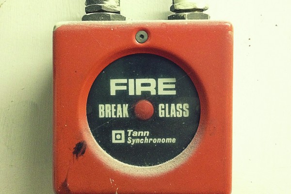 Red retro style fire alarm on the wall