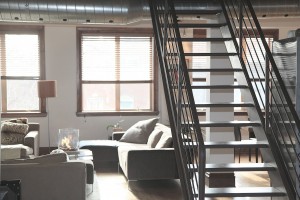 Loft style apartment with a stairtcase and a pipe on the ceiling