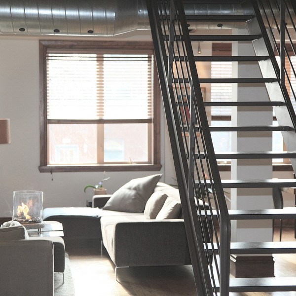 Loft style apartment with a stairtcase and a pipe on the ceiling